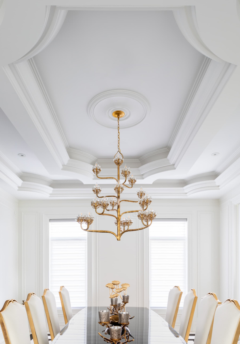 Modern Lighting Ideas from One X One Design. A white dining room where centers a suspension light in gold accents and an armchair in white and gold.