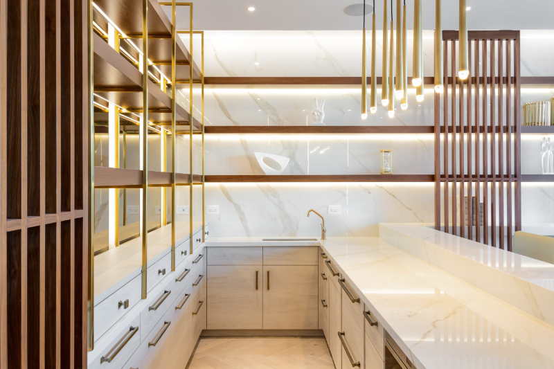 Modern lighting ideas from One X One Design. This white kitchen with accents in wood and gold in the suspension lights.
